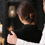 A grieving couple stands together at a funeral, illustrating the emotional impact of losing a loved one in a fatal workplace accident and the legal options available to families pursuing a wrongful death or third-party liability claim.