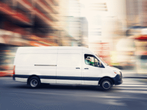White delivery van driving fast through city street